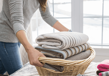 Female homeowner carrying a load of clean laundry