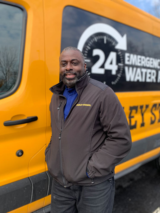 Stanley Steemer of Kalamazoo, MI Manager Marcus Smith Stands in Front of Cleaning Van