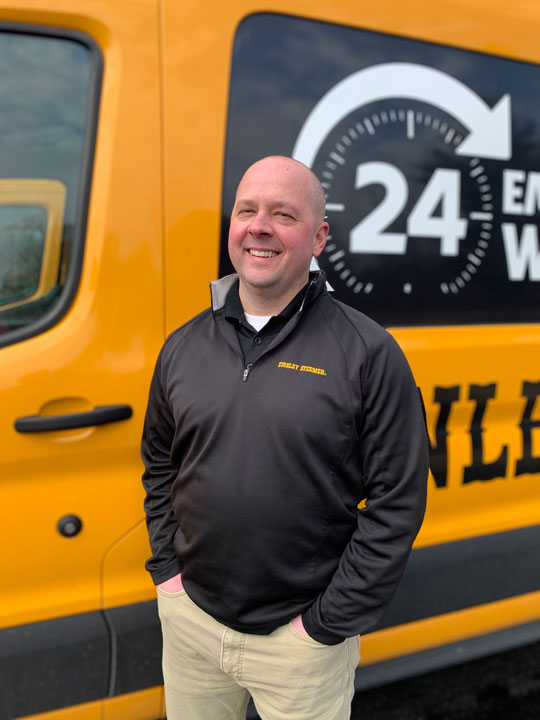 Stanley Steemer of Muskegon, MI Manager Corey Peradis Stands in Front of Cleaning Van