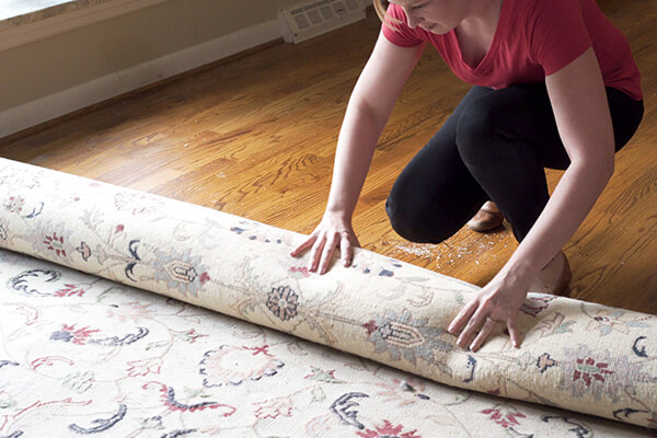 Homeowner clearing area rug from hardwood floor