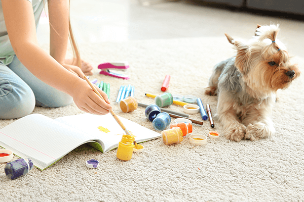 Child Painting on Carpet with Dog