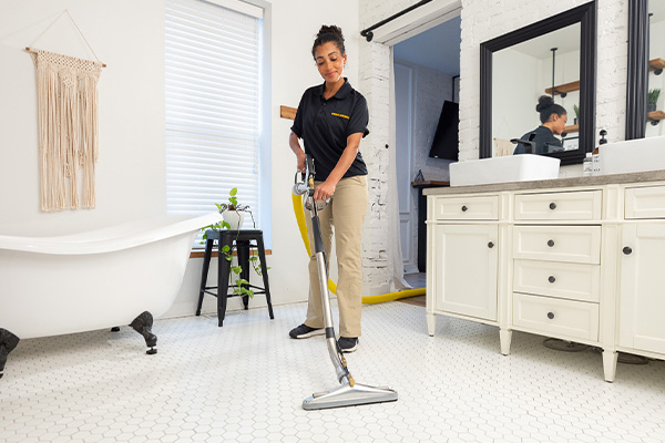 technician cleaning tile and grout in customer bathroom